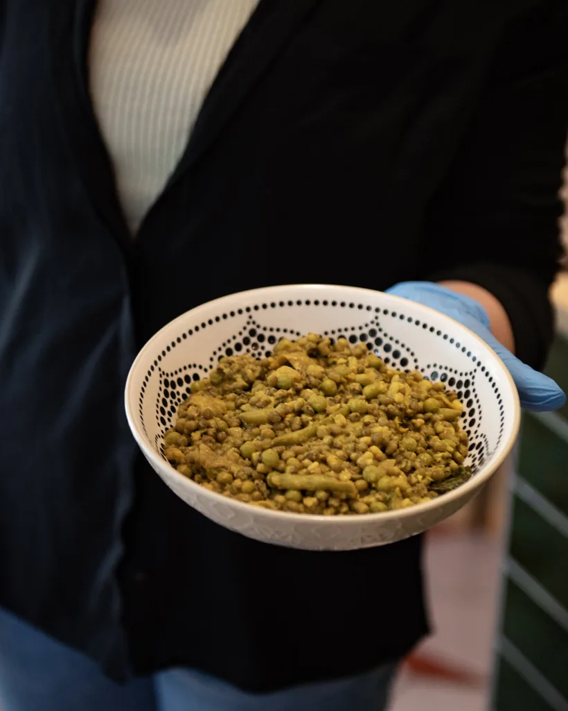 A bowl of granola held out in gloved hands